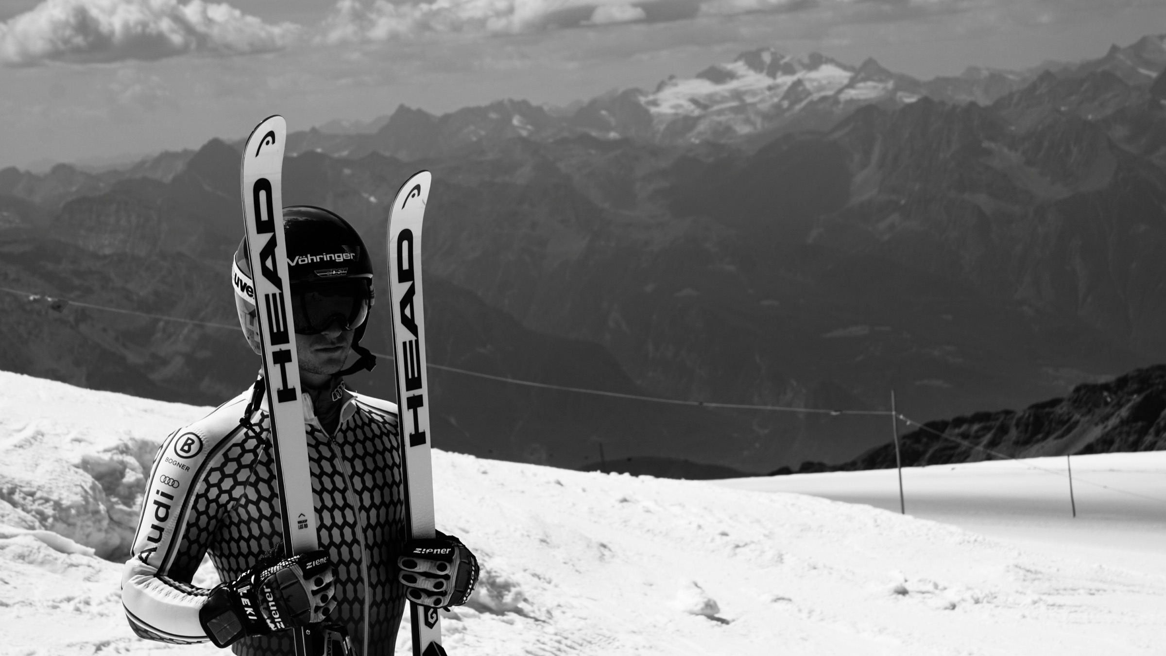 Black-and-white view of skis against an alpine landscape