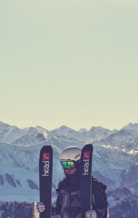 Skis and goggles against the mountains