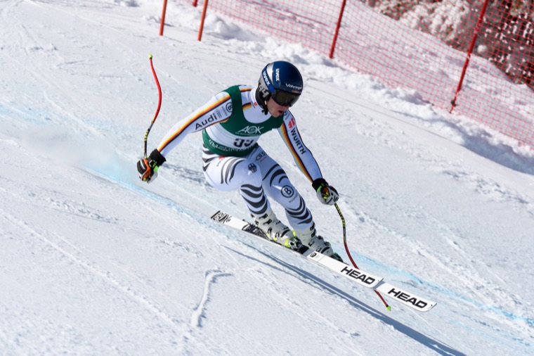 Carving through a speed turn in the German race suit